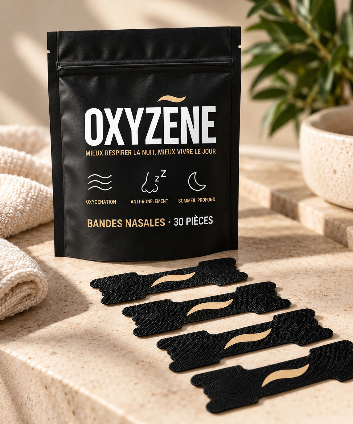 Pack d'essai OXYZÈNE : la pochette et quatre bandes nasales posées sur une salle de bain en travertin