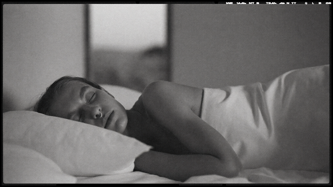 Personne allongée sur le côté, yeux fermés, respirant calmement par le nez pendant la nuit — photographie éditoriale noir et blanc OXYZÈNE