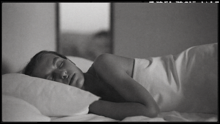 Personne allongée sur le côté, yeux fermés, respirant calmement par le nez pendant la nuit — photographie éditoriale noir et blanc OXYZÈNE